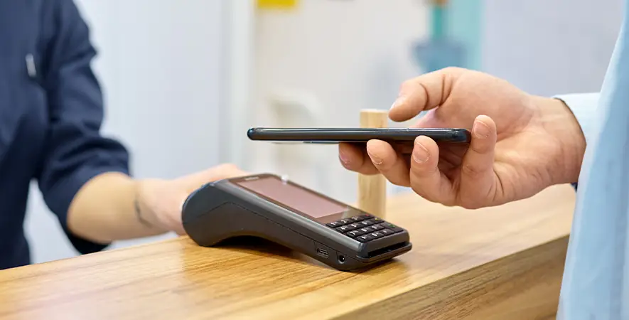 Healthcare professional taking an Apple Pay transaction on a POS device.