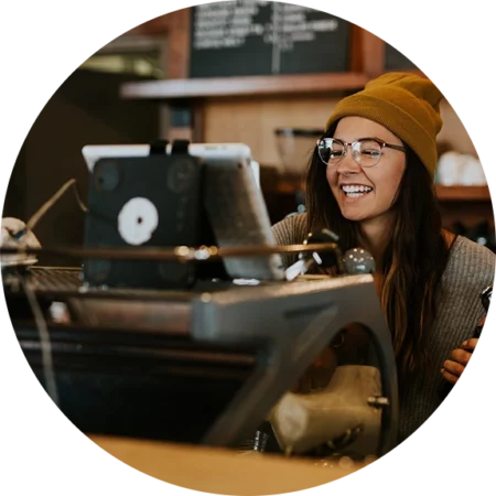 Happy coffee shop employee entering orders in Cluster POS