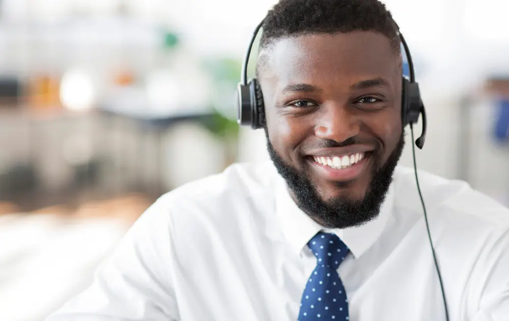 A Payment Expert wearing a phone headset, helping with Clover POS troubleshooting.