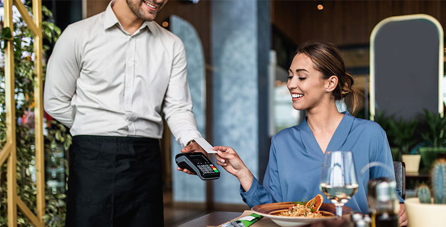 Restaurant customer pays for their meal with a credit card and tableside POS equipment.