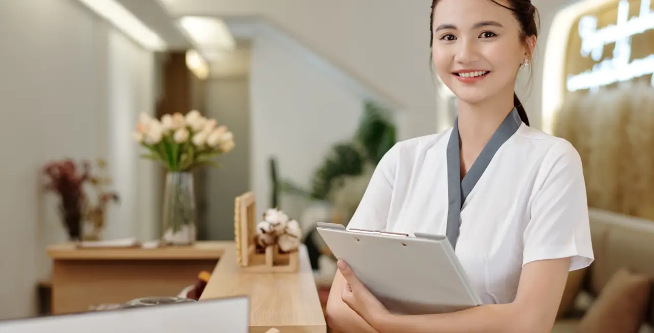 Spa employee smiling at reception