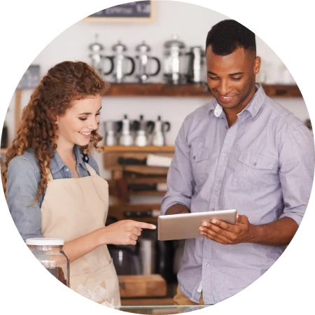 two business owners reviewing daily sales from their stores POS on a tablet