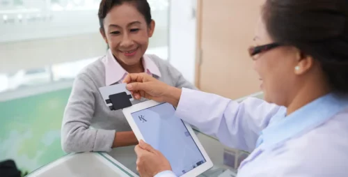 health care clerk swiping client's credit card on a tablet pos card reader
