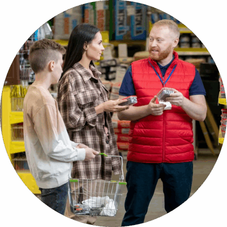 hardware store employee showing a customer and their kid different products and explaining specifics