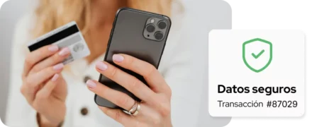 Persona sosteniendo una tarjeta de crédito y un teléfono móvil