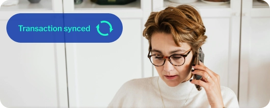 person with short hair and wearing glasses, talking on their mobile phone