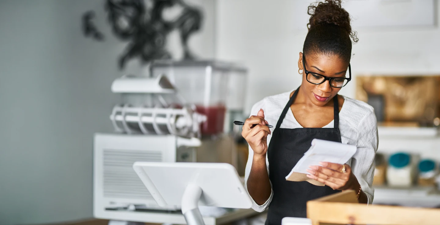 retail store owner tracking inventory by manually writing on inventory pad