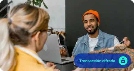 Cliente pasando ropa a empleado de tienda de ropa para efectuar pago