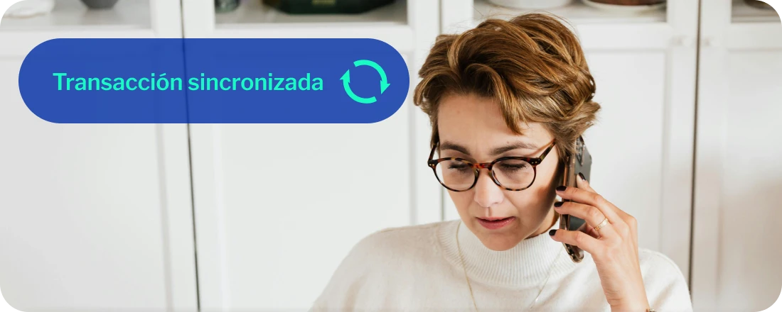 Persona con gafas, con bolígrafo en su mano hablando por teléfono